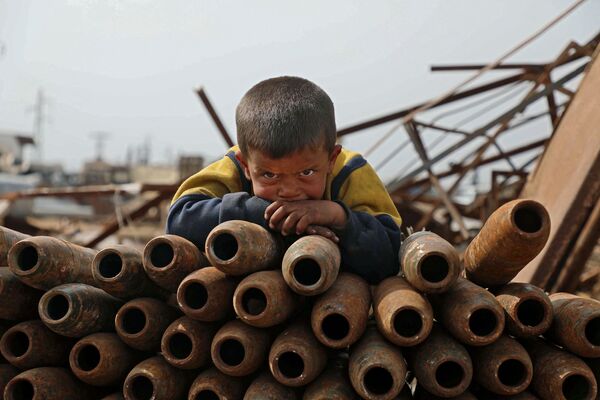 Ребенок на куче нейтрализованных снарядов на свалке металлолома города Маарет-Мисрин в  провинции Идлиб - Sputnik Грузия