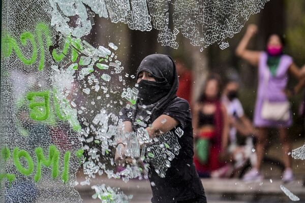 Женщина разбивает стекло в ходе посвященной Международному женскому дню демонстрации в Мексике - Sputnik Грузия