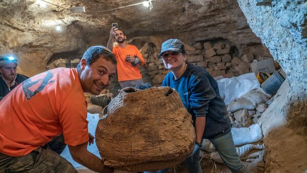 Израильские археологи с древней корзиной, найденной в пещере Мурабаат в Иудейской пустыне недалеко от Мертвого моря - Sputnik Грузия