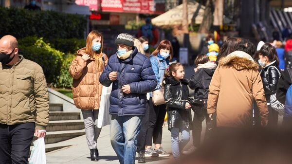 Эпидемия коронавируса -  прохожие в масках на улице - Sputnik Грузия