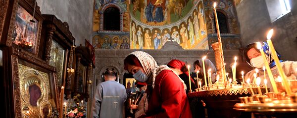 Верующие в церкви ставят свечи на праздник Благовещения - Sputnik Грузия