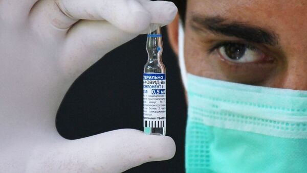 Медицинский работник держит в руках ампулу с российским препаратом от коронавирусной инфекции Гам-Ковид-Вак (Спутник V) - Sputnik Грузия
