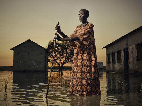 Портрет 70-летней Ньякек, идущей по затопленной улице в Южном Судане, принес британскому фотографу Питеру Кейтону почетное упоминание в конкурсе

 - Sputnik Грузия