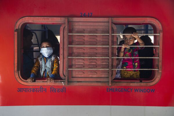 Мальчики смотрят в окно поезда на железнодорожной станции в Гаухати в Индии - Sputnik Грузия
