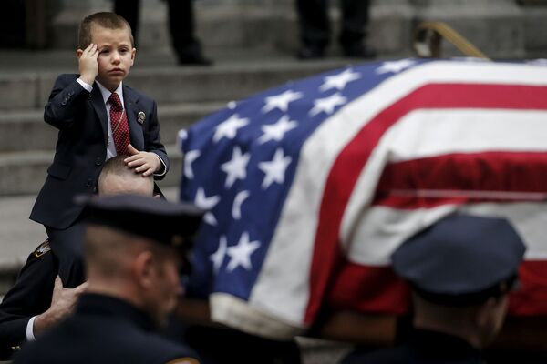 Маленький Райан Лемм отдает честь во время похорон своего отца, офицера полиции Нью-Йорка Джозефа Лемма, который был убит при исполнении служебных обязанностей в Афганистане. 30 декабря 2015 года - Sputnik Грузия