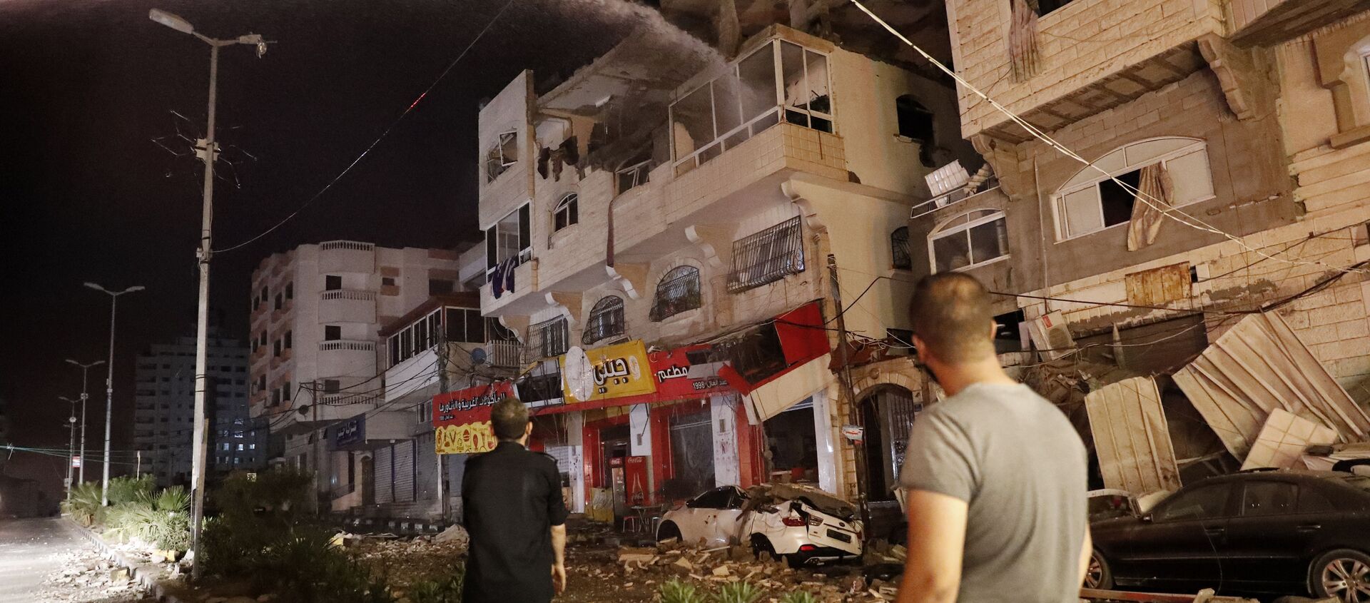 Пожарные тушат горящие жилые дома после того, как они пострадали от израильских авиаударов, в городе Газа - Sputnik Грузия, 1920, 14.05.2021