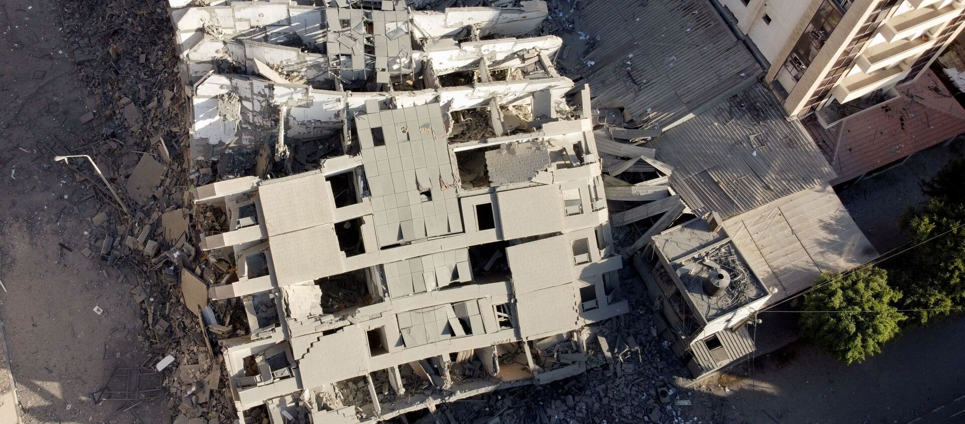 На снимке, сделанном с помощью беспилотника, видны руины здания, разрушенного в результате израильских воздушных ударов, на фоне вспышки израильско-палестинского конфликта в городе Газа - Sputnik Грузия, 1920, 17.05.2021
