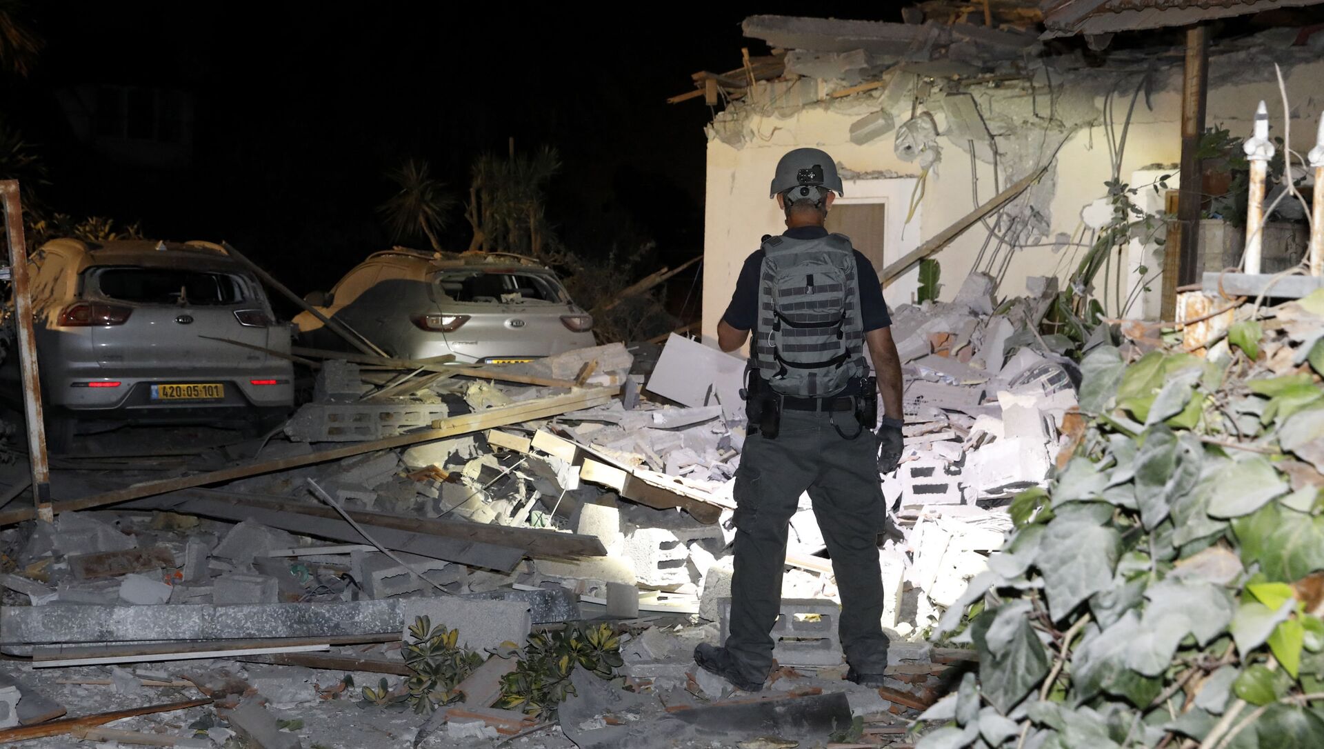 Офицер службы безопасности Израиля осматривает повреждения дома в Йехуде, недалеко от Тель-Авива - Sputnik Грузия, 1920, 13.05.2021