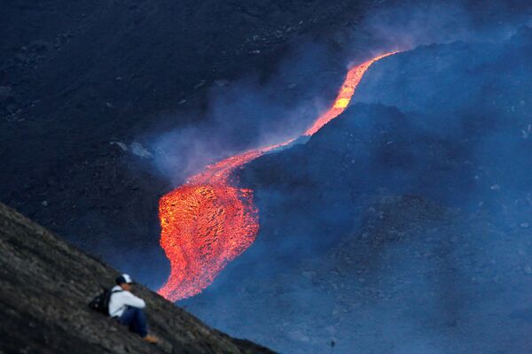 Мужчина наблюдает за течением раскаленной лавы вулкана Пакая в регионе Эскуинтла, Гватемала - Sputnik Грузия