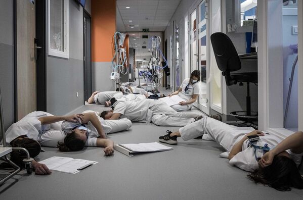 Медсестры и медперсонал лежат на полу в отделении интенсивной терапии во время демонстрации в Международный день медсестер и ухода в больнице Mont Legia в Бельгии - Sputnik Грузия