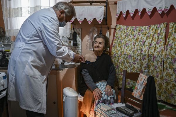 Безусловно, вакцинироваться можно в медицинском учреждении, но иногда это бывает скучно, и к вопросу решили подойти креативно. На фото: доктор Анаргирос Мариолис вакцинирует пожилую женщину от COVID-19 на острове Элафониссос - Sputnik Грузия