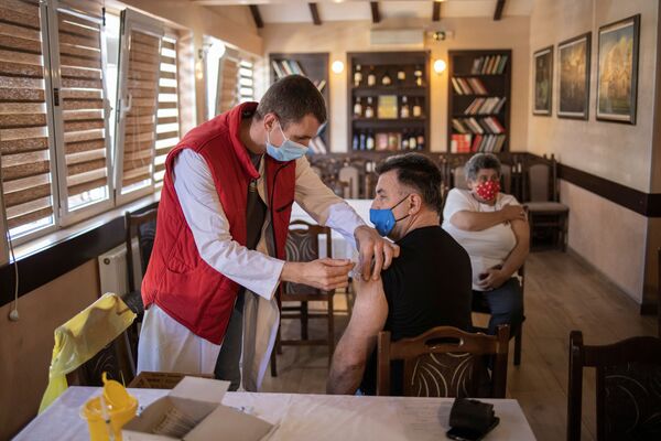 Мужчина получает дозу китайской вакцины Sinopharm против коронавирусной болезни (COVID-19) в ресторане в Сербии - Sputnik Грузия