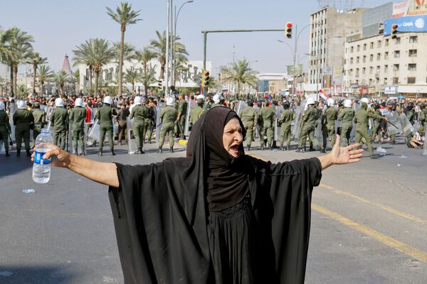 Женщина жестикулирует, когда демонстранты принимают участие в антиправительственной акции протеста в Багдаде - Sputnik Грузия