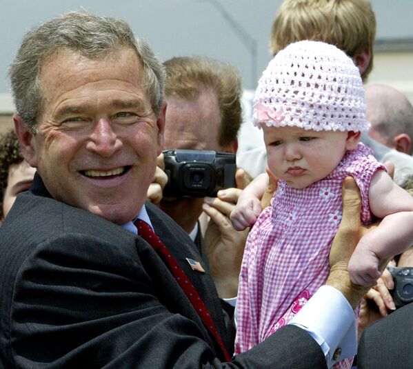 Президент США Джордж Буш с ребенком в аэропорту - Sputnik Грузия