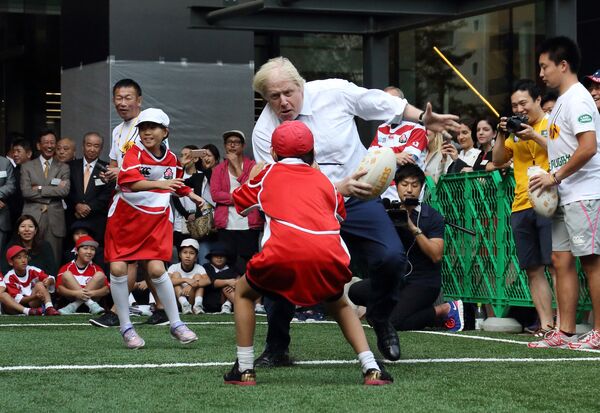 Мэр Лондона Борис Джонсон во время игры в регби со школьниками в Токио - Sputnik Грузия