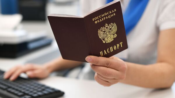Сотрудник ПФР держит в руках паспорт РФ. - Sputnik Грузия