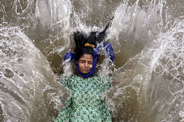 გოგონა მუმბაიში მოსული უძლიერესი მუსონური წვიმის შემდეგ ქუჩაში დამდგარ წყალში თამაშობს   - Sputnik საქართველო