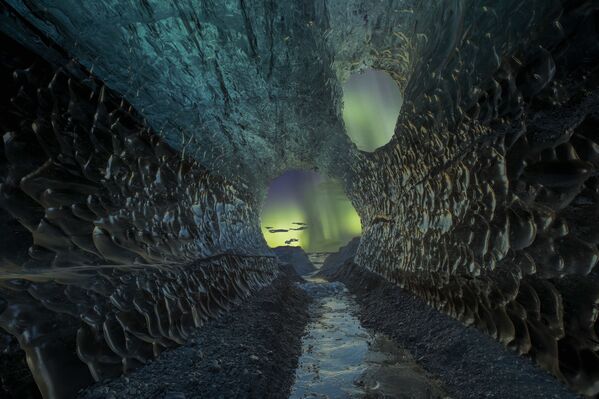 Во время визита в Исландию фотографу удалось сделать двойную экспозицию - одну из пещеры и одну из северного сияния. Погодные условия в тот день были идеальными, и конечный результат вышел соответствующим
 - Sputnik Грузия
