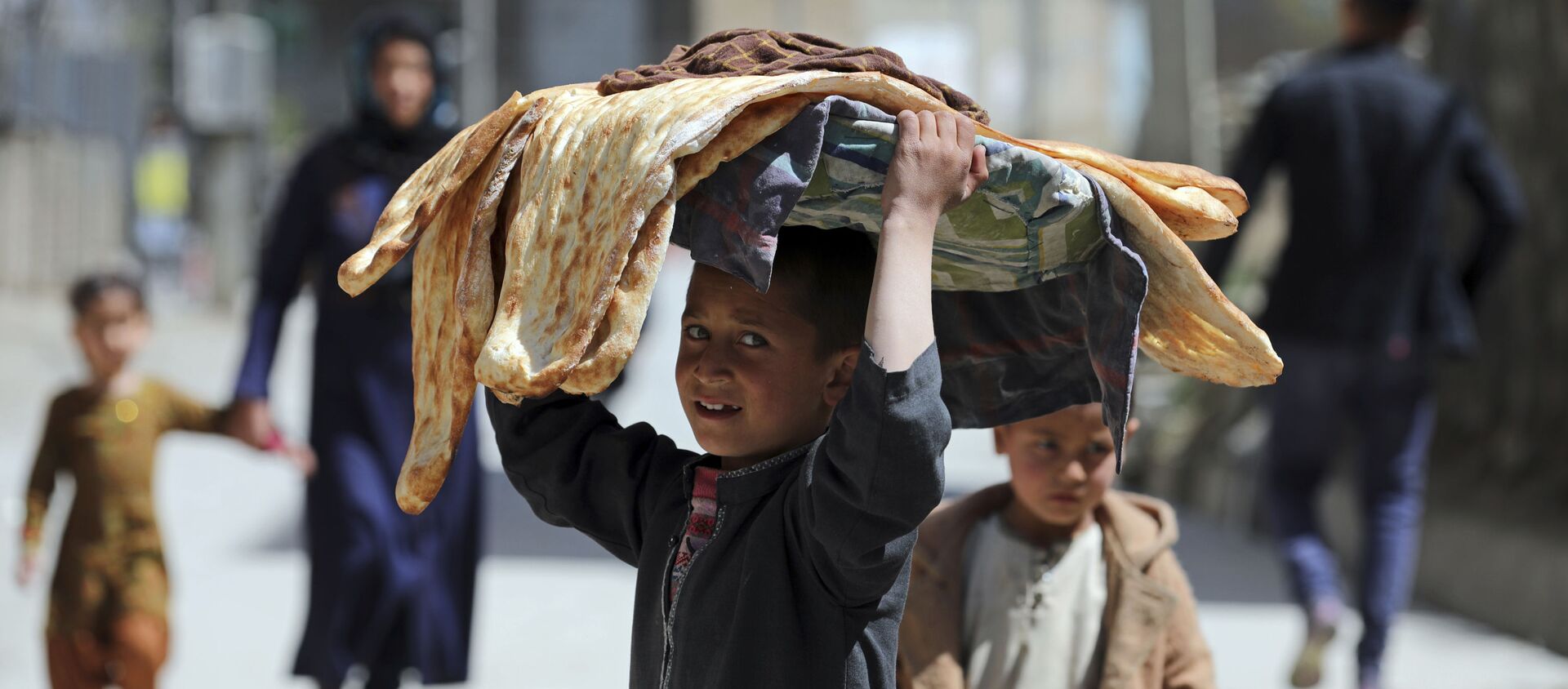 Мальчик с хлебом на голове на одной из улиц Кабула, Афганистан - Sputnik Грузия, 1920, 08.07.2021