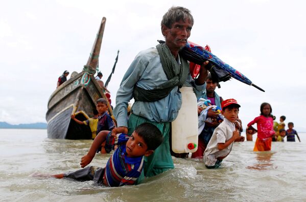  Беженец-рохинджа с ребенком после пересечения границы Бангладеш и Мьянмы на лодке через Бенгальский залив в Шах-Порир-Двипе, Бангладеш - Sputnik Грузия