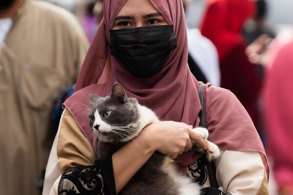 მუსლიმი ქალი კატით ხელში ცისფერ მეჩეთში ყურბან-ბაირამის დილის ლოცვის შემდეგ. ქალაქი თაგიგი, ფილიპინები - Sputnik საქართველო