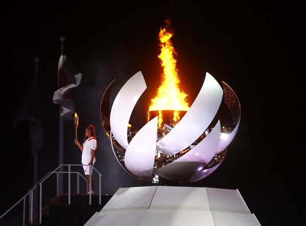 Наоми Осака из Японии держит олимпийский факел после зажжения олимпийского огня на церемонии открытия  - Sputnik Грузия
