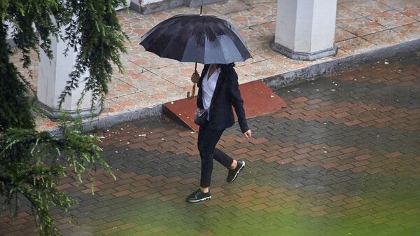 Женщина идет с зонтом под дождем - Sputnik Грузия