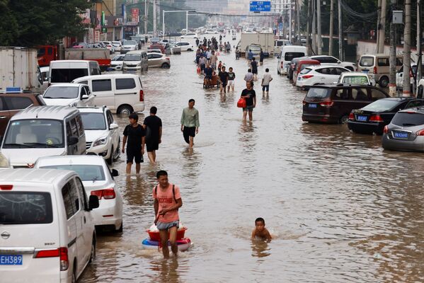 Люди бредут по затопленному Чжэнчжоу, провинция Хэнань. Многие бросают имущество, спасая свою жизнь - Sputnik Грузия