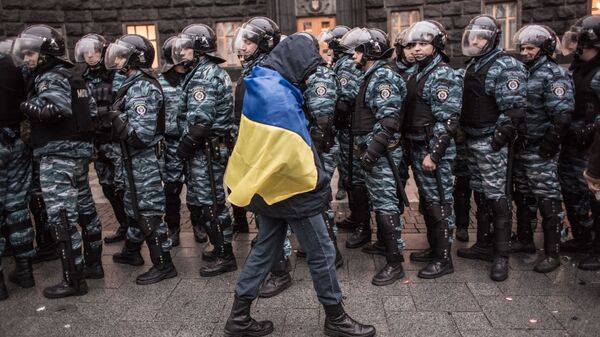 Сторонник евроинтеграции Украины и сотрудники милиции у здания правительства страны в Киеве - Sputnik Грузия