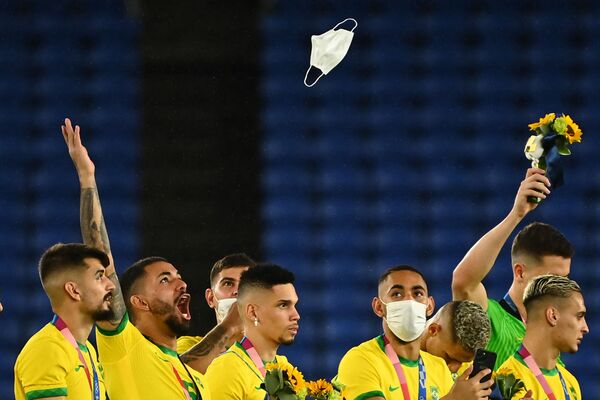 Бразильский футболист Дуглас Луис бросает свою маску в воздух во время церемонии награждения победителей Олимпийских игр 2020 года в Токио - Sputnik Грузия