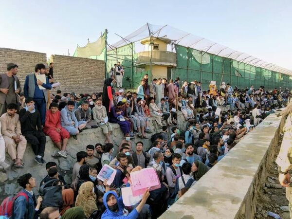 У стены международного аэропорта в Кабуле, который является единственной возможностью покинуть страну, ждут тысячи человек. Все наземные пограничные переходы из Афганистана контролируются талибами - Sputnik Грузия