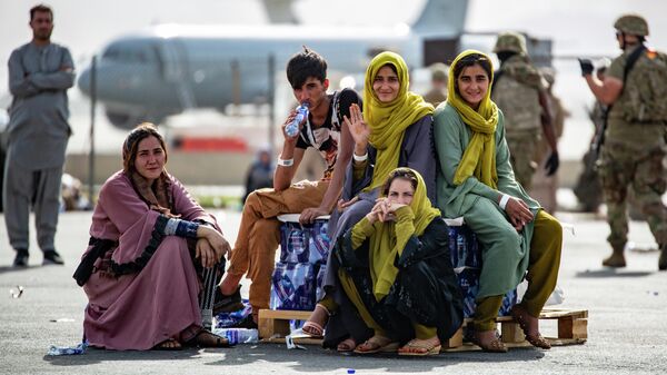 Эвакуированные женщины и дети ждут рейса в международном аэропорту Хамида Карзая в Кабуле - Sputnik Грузия