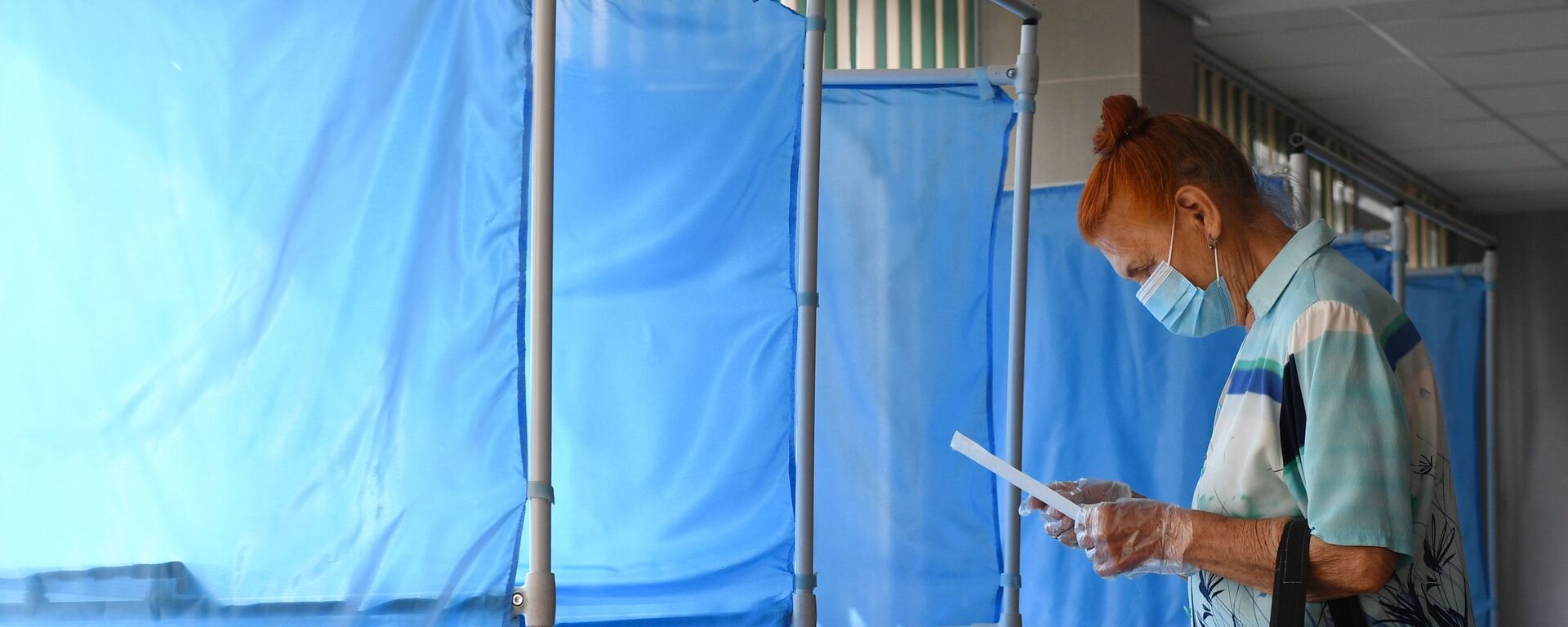 Женщина принимает участие в голосовании по внесению поправок в Конституцию РФ на избирательном участке №1503 в Новосибирске - Sputnik Грузия, 1920, 20.09.2021