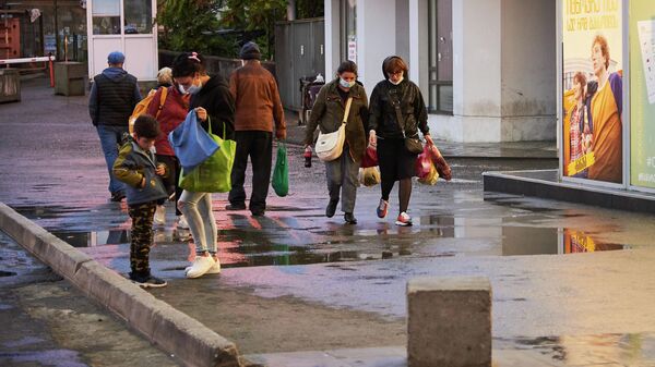 Эпидемия коронавируса - прохожие на улице в масках с покупками, Вокзальная площадь - Sputnik Грузия
