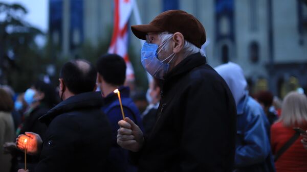 Акция протеста сторонников Саакашвили. Люди в масках с горящими свечами в руках - Sputnik Грузия