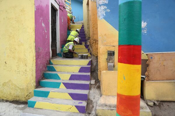 Рабочие раскрашивают лестницу под цвет ярких стен соседних домов - Sputnik Грузия