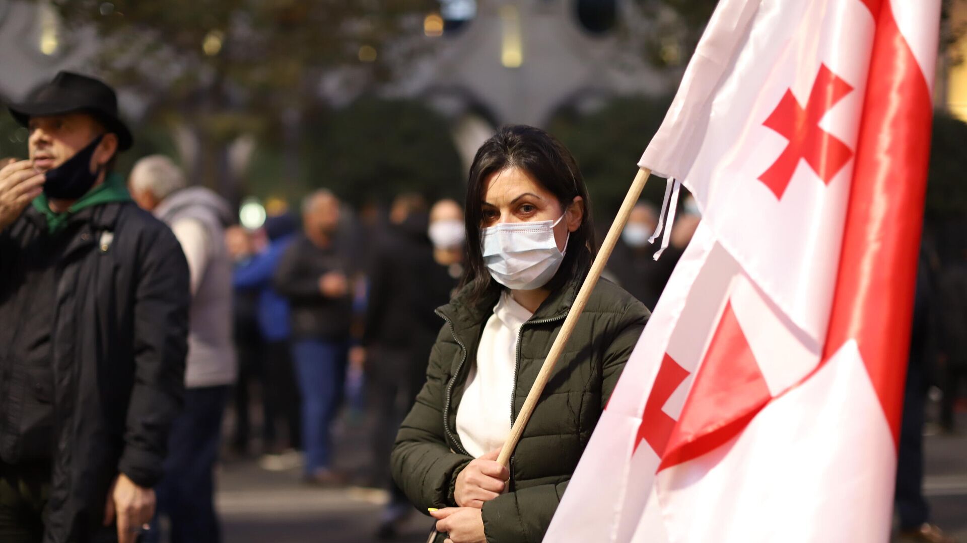 Акция оппозиции и ЕНД в поддержку Саакашвили. Женщина в маске держит флаг Грузии - Sputnik Грузия, 1920, 31.05.2022