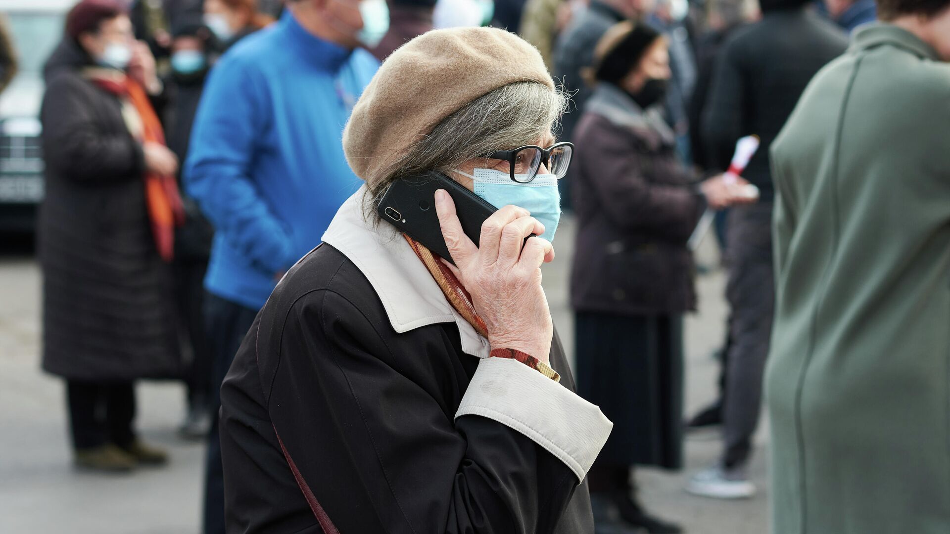 Эпидемия коронавируса - пожилые люди на улице в масках. Женщина говорит по телефону - Sputnik Грузия, 1920, 01.12.2021
