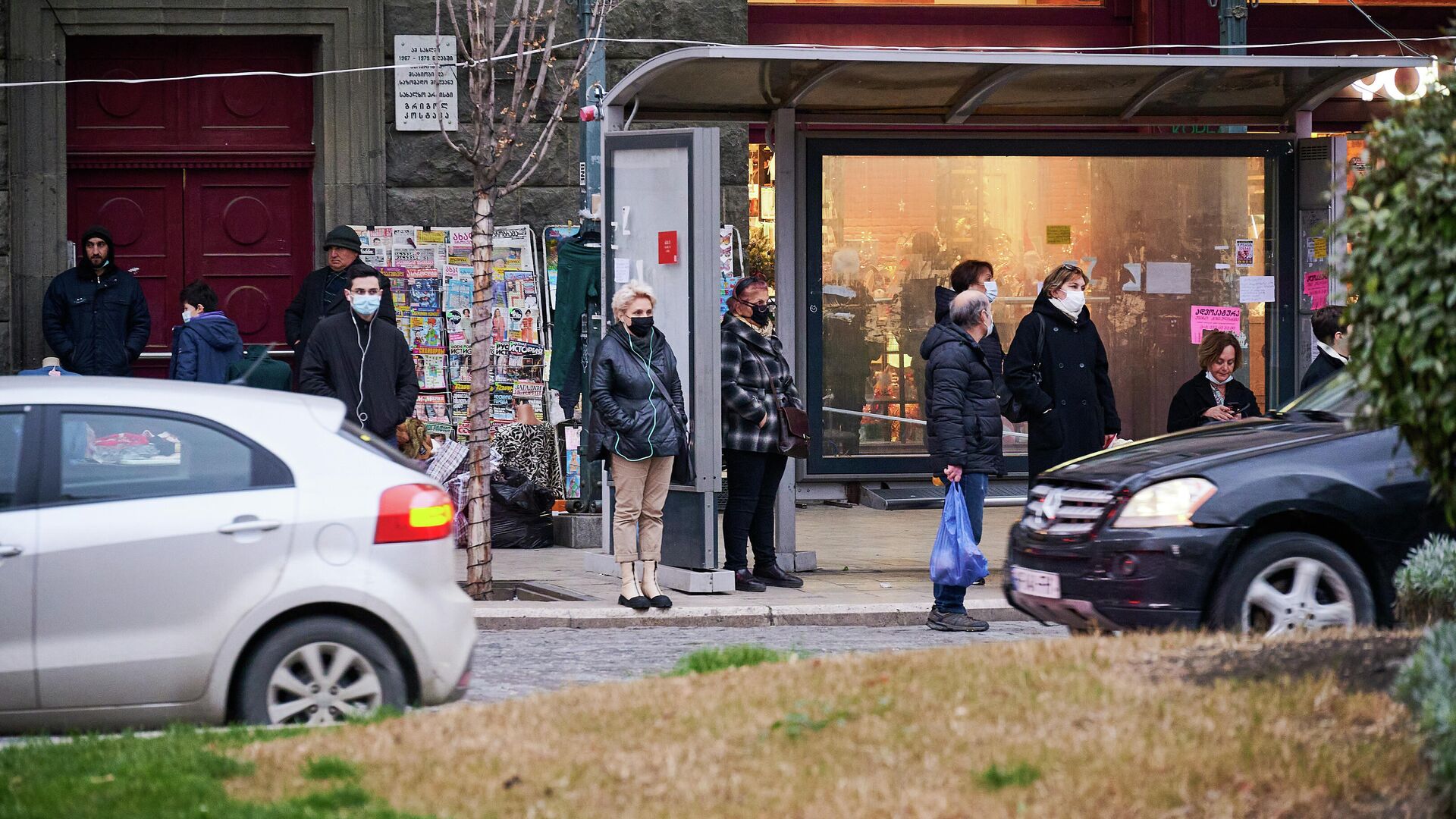 Эпидемия коронавируса - прохожие на улице в масках на автобусной остановке - Sputnik Грузия, 1920, 19.12.2021
