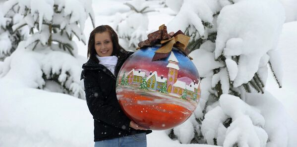Женщина держит в руках один из самых больших в мире рождественских шаров, изготовленный стекольной фабрикой Joska Kristall - Sputnik Грузия