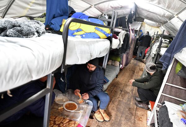 Беженцы едят в палатке в лагере для мигрантов &quot;Липа&quot;, который был восстановлен после пожара в декабре 29 января 2021 года недалеко от северо-западного боснийского города Бихач - Sputnik Грузия