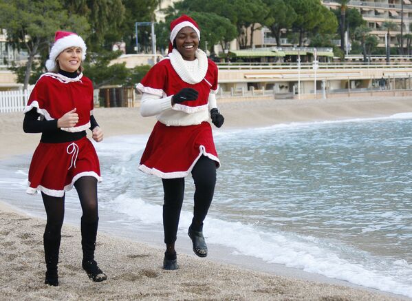 Девушки в костюмах Санта-Клауса совершают пробежку перед зимним купанием в Средиземном море - Sputnik Грузия