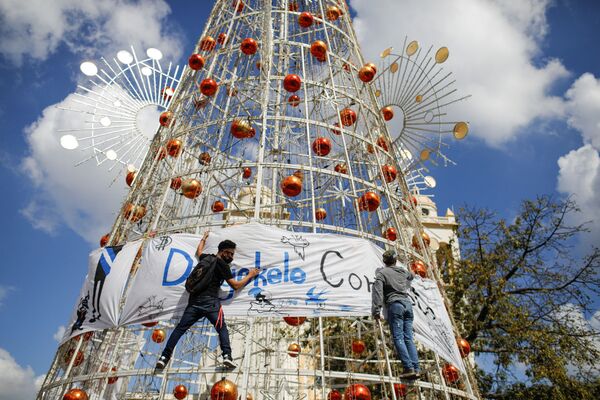 Активисты вешают баннер на елку во время акции протеста в Сан-Сальвадоре - Sputnik Грузия