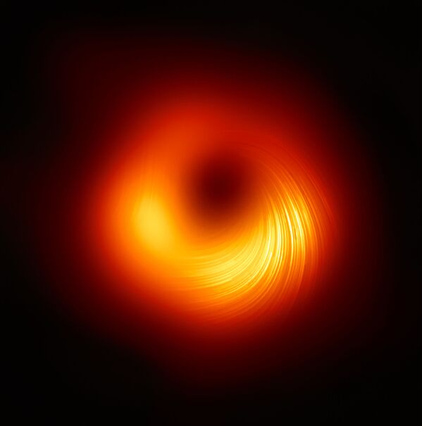 Изображение телескопа Event Horizon, демонстрирующее поляризованный вид черной дыры M87. Линии обозначают ориентацию поляризации, которая связана с магнитным полем вокруг тени черной дыры - Sputnik Грузия