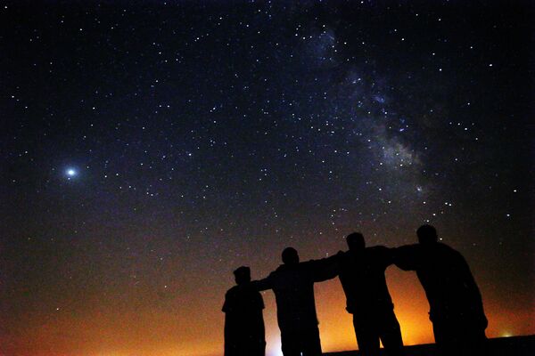 Друзья рассматривают Млечный Путь, восходящий в ночном небе пустыни Кувейта в 120 км к северу от столицы - Sputnik Грузия