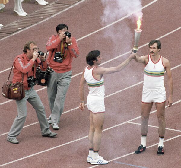 Олимпийский чемпион Сергей Белов (справа) принимает факел с олимпийским огнем из рук трехкратного олимпийского чемпиона Виктора Санеева (слева) на Олимпийских играх 1980 года в Москве - Sputnik Грузия