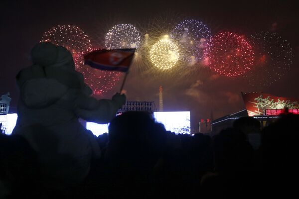 Горожане смотрят на фейерверк в честь Нового года на площади Ким Ир Сена в Пхеньяне - Sputnik Грузия
