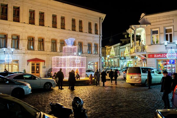 Так жители Кутаиси проводят праздничные новогодние вечера - любуются красиво  украшенными улицами, поздравляют друг друга, ходят в гости.  - Sputnik Грузия