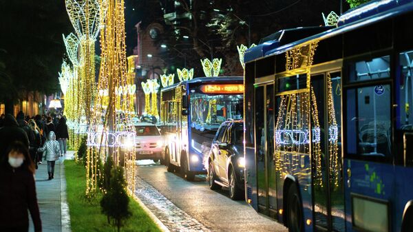 Город Кутаиси ночью. Новогодняя иллюминация. Огни отражаются в стеклах автобусов - Sputnik Грузия