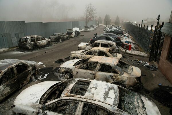 Участники беспорядков сожгли только в Алма-Ате десятки, если не сотни машин. На снимке - сожженные автомобили на паркинге в центре Алма-Аты - Sputnik Грузия